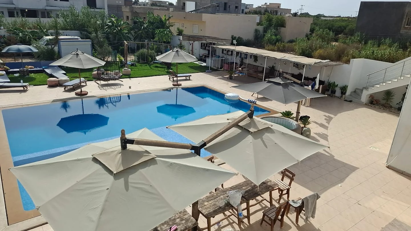 Dar Lekhlaa à Dar Allouche : vue d'ensemble de la piscine, des terrasses ombragées et du jardin